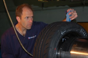 Dave Kaemmer takes measurements of a racing tire for research purposes